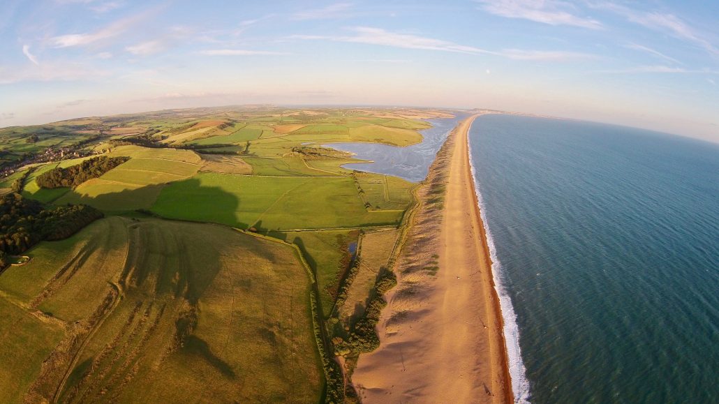 Visit-Dorset - A fantastic shot over Chesil Beach and the Fleet Nature  Reserve. 💦⁠ Chesil beach is a bank of pebbles stretching for 18 miles  along the Dorset Coast. Trapped behind this
