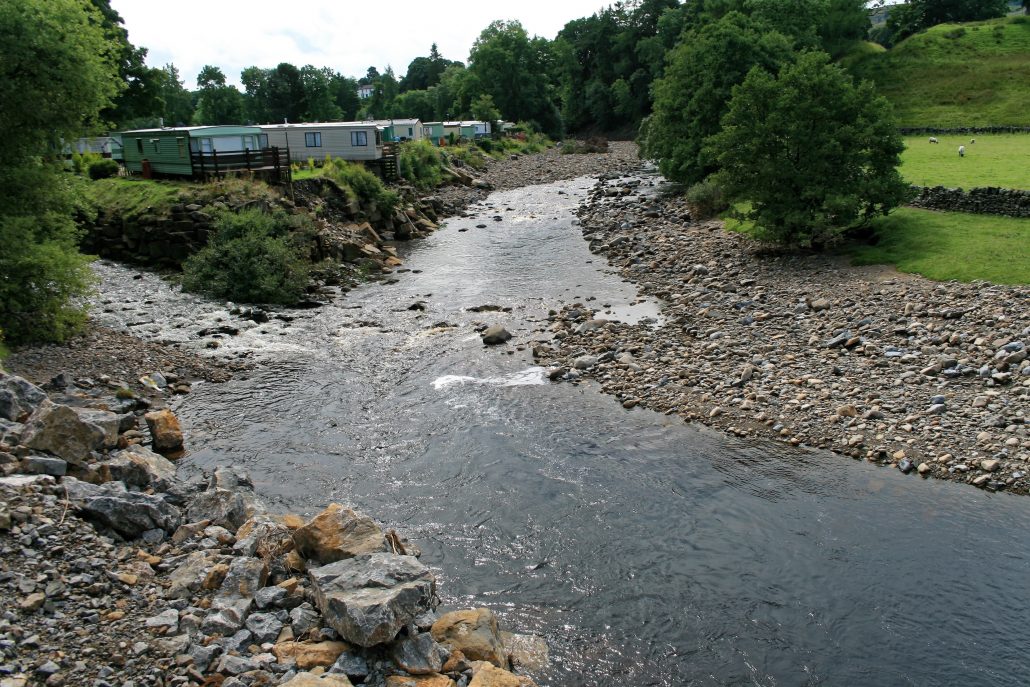 A confluence in a river. A smaller tributary flows into the main river.