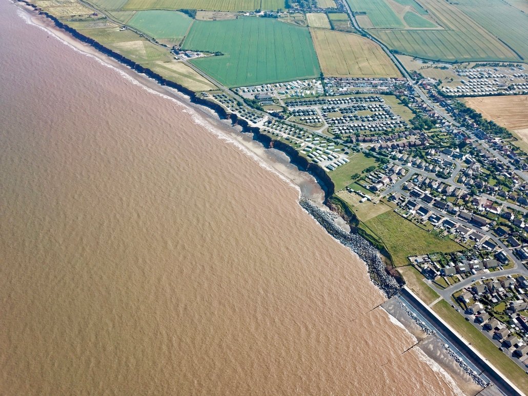 Downdrift of the sea defences at Withernsea , the adjacent undefended coast is being eroded resulting in a set back.