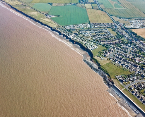 Downdrift of the sea defences at Withernsea , the adjacent undefended coast is being eroded resulting in a set back.