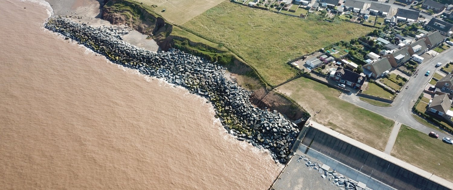 Downdrift of the sea defences at Withernsea , the adjacent undefended coast is being eroded resulting in a set back.