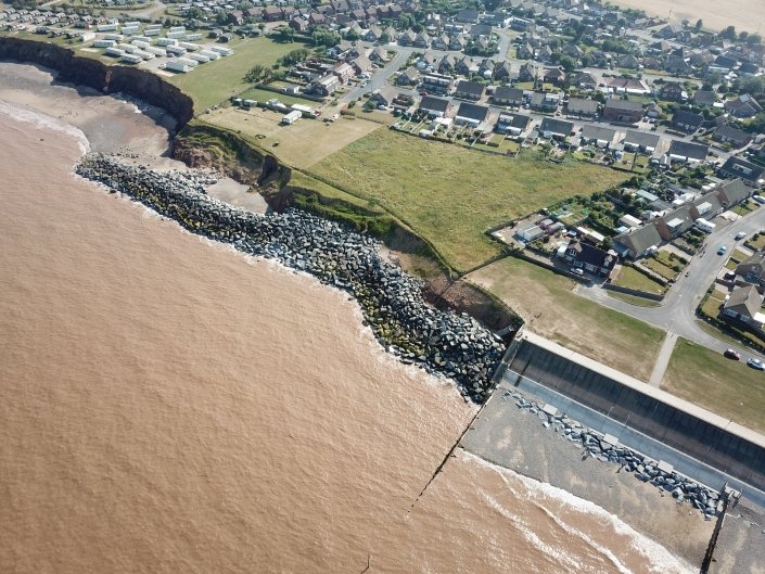 Downdrift of the sea defences at Withernsea , the adjacent undefended coast is being eroded resulting in a set back.