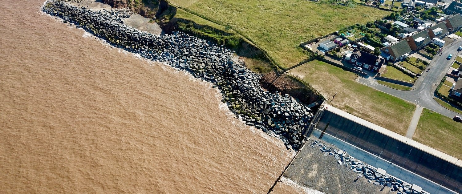 Downdrift of the sea defences at Withernsea , the adjacent undefended coast is being eroded resulting in a set back.