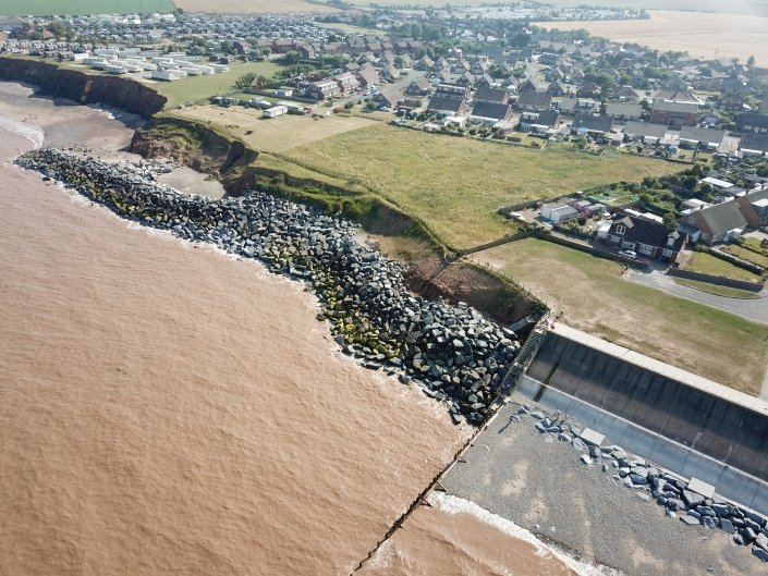 Downdrift of the sea defences at Withernsea , the adjacent undefended coast is being eroded resulting in a set back.