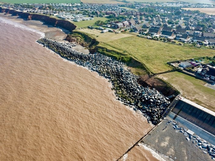 Downdrift of the sea defences at Withernsea , the adjacent undefended coast is being eroded resulting in a set back.