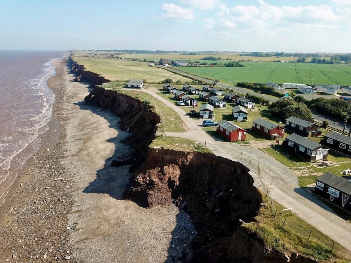 Downdrift of the sea defences at Withernsea , the adjacent undefended coast is being eroded resulting in a set back.