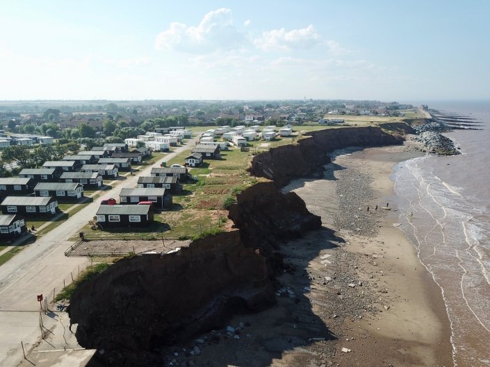 Downdrift of the sea defences at Withernsea , the adjacent undefended coast is being eroded resulting in a set back.