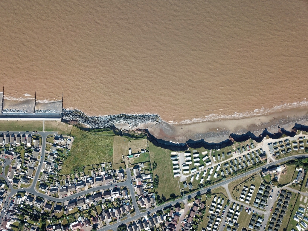 Downdrift of the sea defences at Withernsea , the adjacent undefended coast is being eroded resulting in a set back.