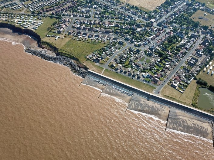 Downdrift of the sea defences at Withernsea , the adjacent undefended coast is being eroded resulting in a set back.