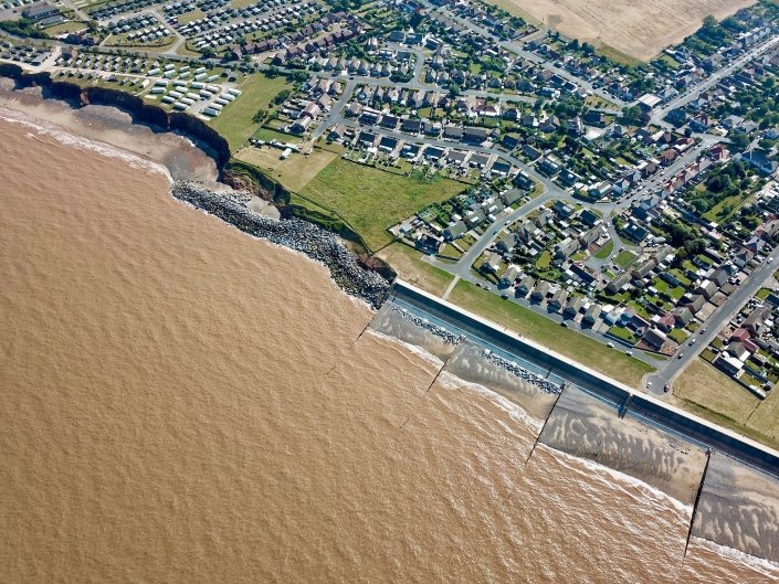 Downdrift of the sea defences at Withernsea , the adjacent undefended coast is being eroded resulting in a set back.