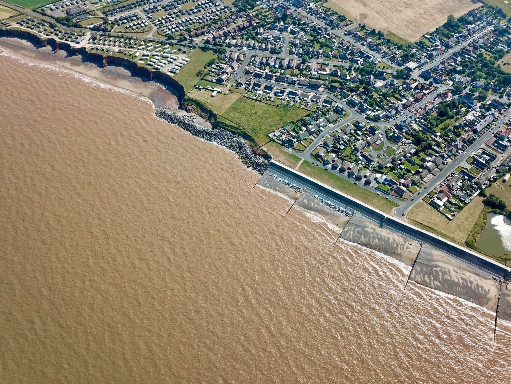 Downdrift of the sea defences at Withernsea , the adjacent undefended coast is being eroded resulting in a set back.