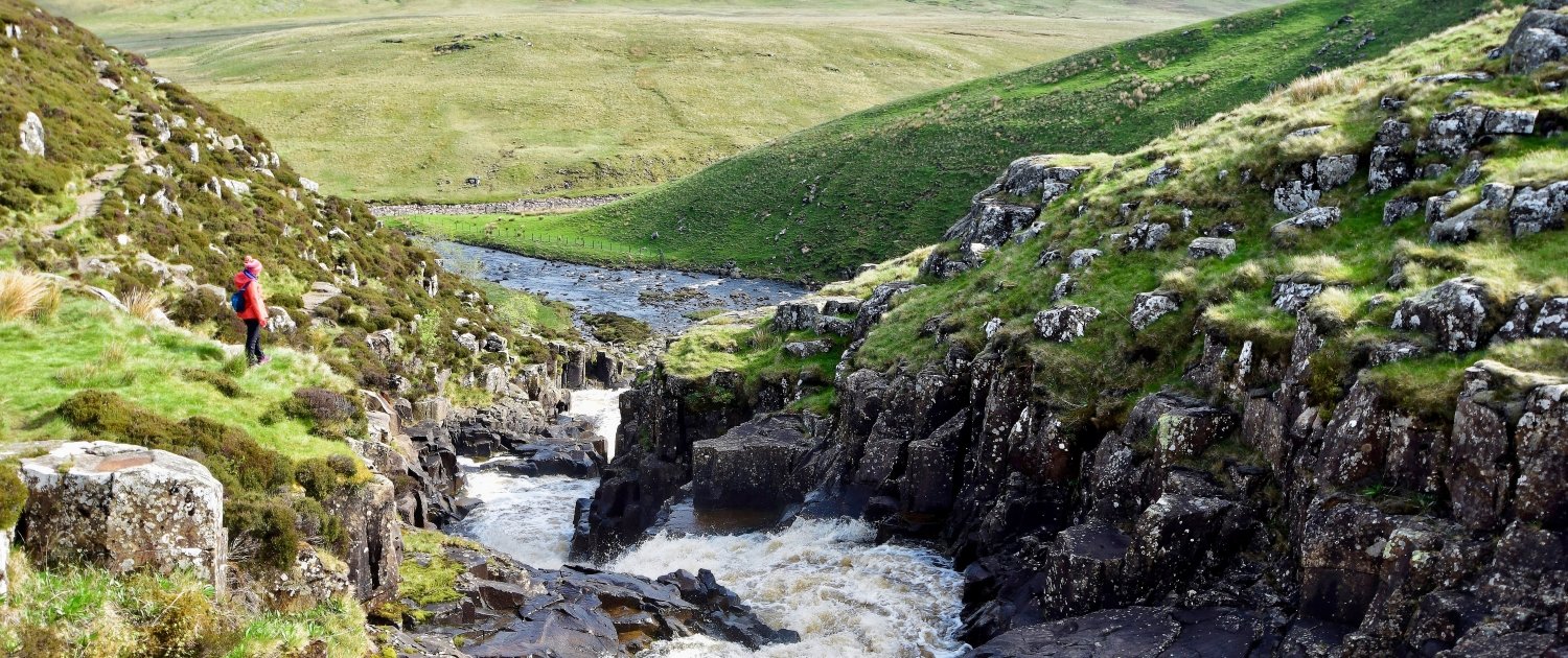 The upper course of a river with rapids as the river flows through steep V-shaped valleys.