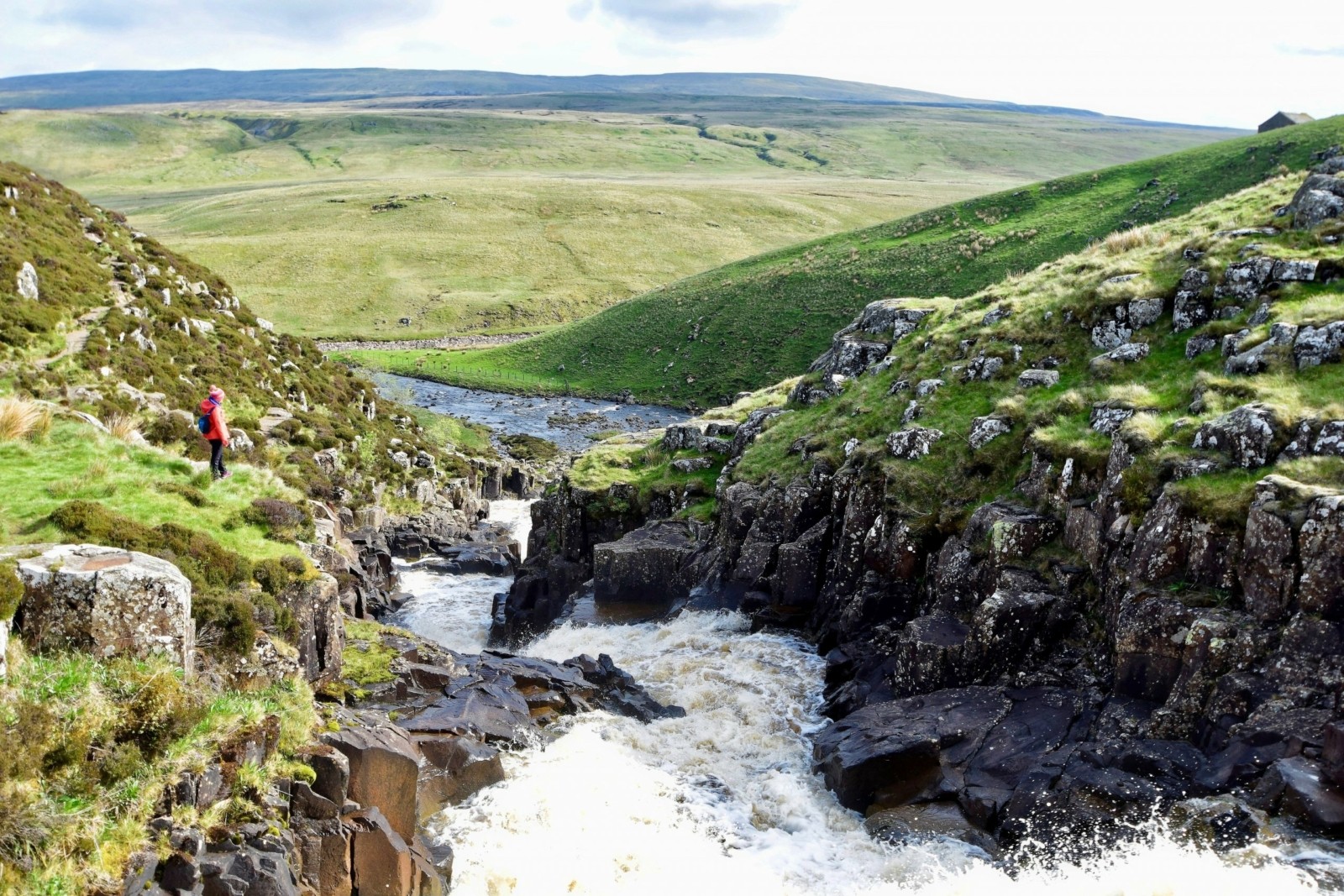 The upper course of a river with rapids as the river flows through steep V-shaped valleys.