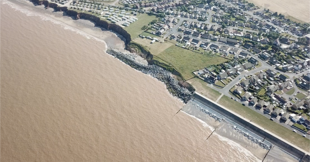 Impact of erosion down drift of defences