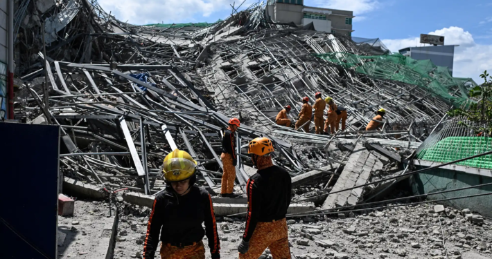 Emergency services work at the site of a collapsed building following the earthquakes in Caracas